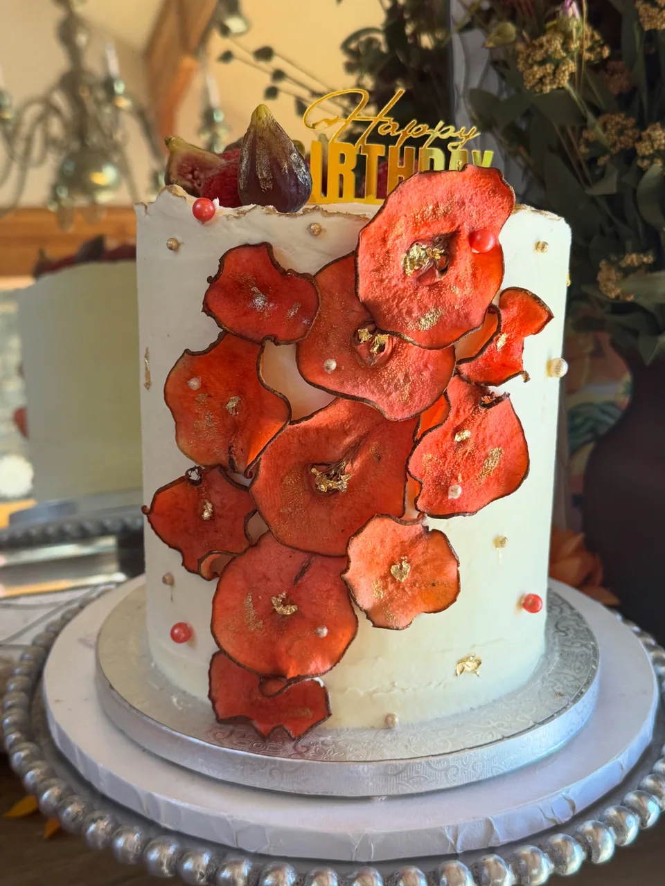 A birthday cake with red pear-slice flowers