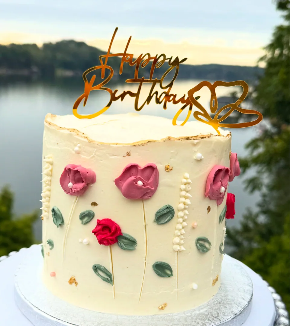 A pale green birthday cake with piped roses