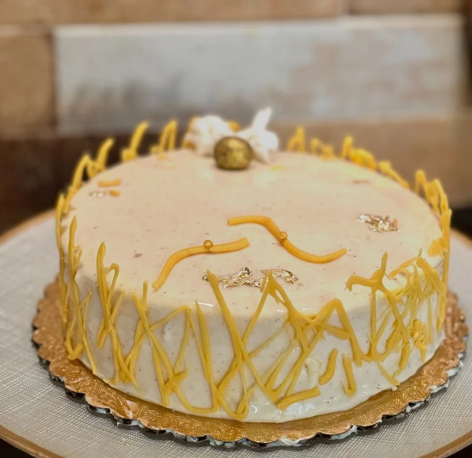 A yellow cake with fine branch-like decoration